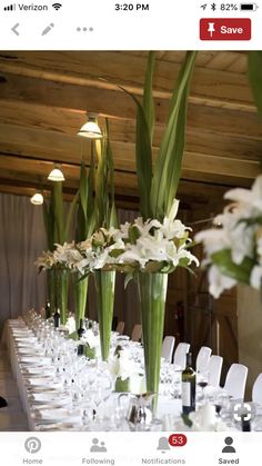 the long table is set with white flowers and place settings