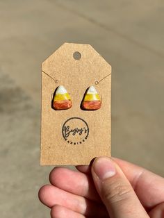 a person holding up a tag with some earring designs on it's ears