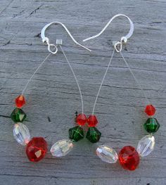 a pair of red and green beaded earrings on wooden table next to ear wires