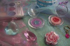 various items are displayed on a table with pink and blue accessories around them, including earrings