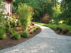 a walkway in front of a house surrounded by trees