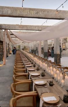 the long table is set with candles and place settings for people to sit down at