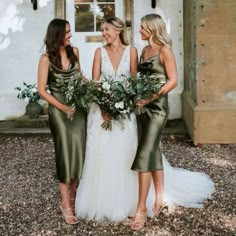 three bridesmaids in green dresses standing outside the house with their bouquets together