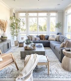 a living room filled with lots of furniture and decor on top of a white rug