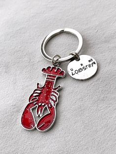 a close up of a keychain with a heart and a boxing glove on it