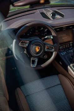 the interior of a sports car with steering wheel and dashboard