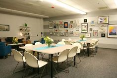 a room with chairs, tables and pictures on the wall