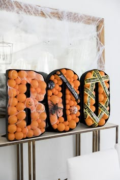 three bags filled with oranges sitting on top of a shelf