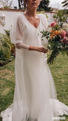 a woman in a white dress holding flowers