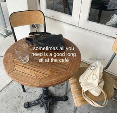 a wooden table sitting next to a chair on top of a cement floor near a door