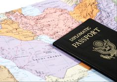 a black passport sitting on top of a map