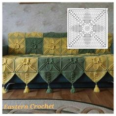 a crocheted couch with yellow and green afghans on it, in front of a