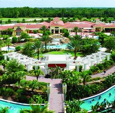 an aerial view of a resort pool surrounded by palm trees