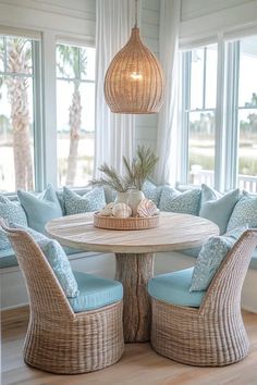 a round table with chairs around it in front of large windows