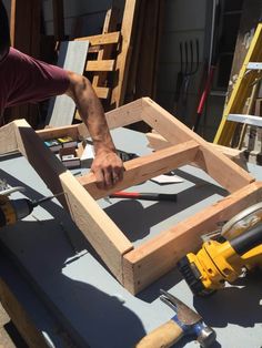 a man is working on some wood in the process of being made into a frame