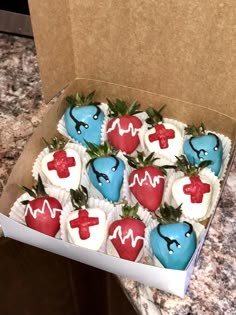 a box filled with heart shaped cupcakes sitting on top of a marble counter