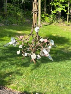 a chandelier hanging from the side of a tree in a yard with grass