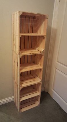 a tall wooden shelf sitting next to a door in a room with carpeted flooring