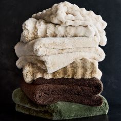 towels stacked on top of each other in front of a black background with white and brown colors