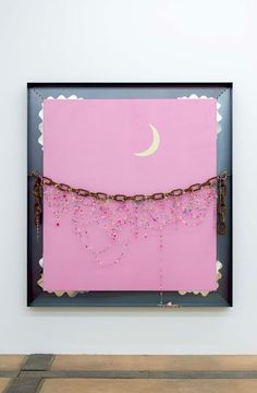 a pink painting with chains hanging from it's sides and a half moon in the background