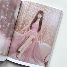 an open book with a photo of a woman in a pink dress