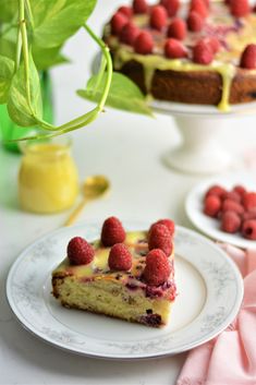 a piece of cake on a plate with raspberries