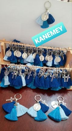 blue and white tasselled keychains are on display in front of a sign that says kaanemey