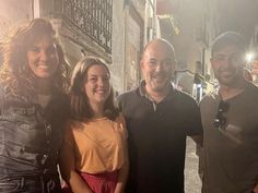 three people standing next to each other on a street