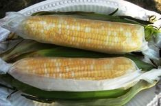 two ears of corn on a paper plate