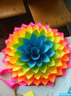 a colorful paper flower sitting on top of a table