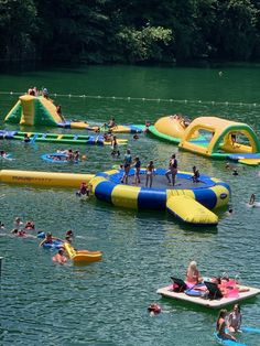 people are floating on inflatable rafts and having fun at the lake while others swim nearby