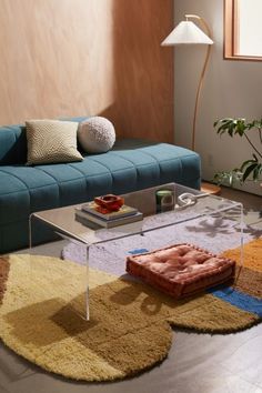 a living room with a couch, coffee table and rugs on the floor in front of it