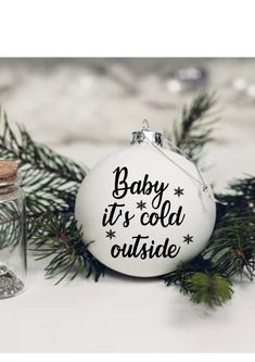 baby it's cold outside ornament with pine branch and glass jar on white background