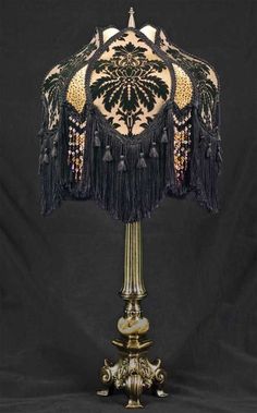 a black and gold lamp with tassels on it