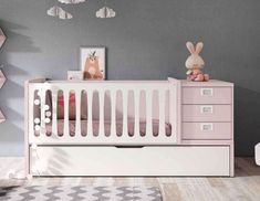 a baby's room with grey walls and pink furniture