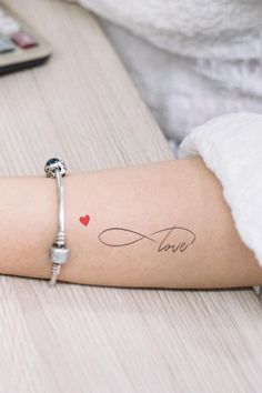 a woman's arm with a tattoo on it that says love and a heart