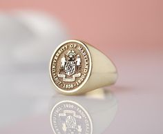 Introducing our stunning 14k Solid Gold custom college class signet ring! This exquisite piece is the perfect way to commemorate your academic achievement in style. Crafted with top-quality materials, this unique ring can be tailored to feature your graduation year or college insignia for a personalized touch. Whether as a gift for yourself or a loved one, this ring is sure to be cherished for years to come. Make a statement with this timeless keepsake that celebrates your academic journey in a Gold Jewelry With Engraved Logo For Formal Occasions, Graduation Rings College, Class Rings College, Graduation Rings, College Classes, Gold Signet Ring, Jewelry Workshop, Personalized Products, Signet Ring