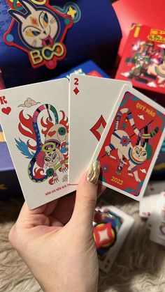 a person holding three playing cards in their hand