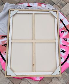 an unfinished window sitting on top of a pink and white blanket