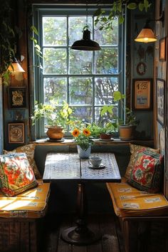 a table and two benches in front of a window with potted plants on it