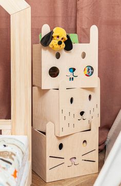 a wooden toy house with a stuffed animal on top