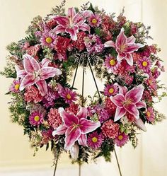 a wreath with pink flowers and greenery