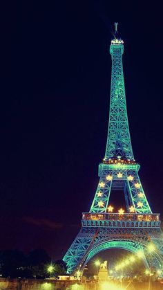 the eiffel tower lit up at night with lights on it's sides