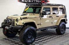 a beige jeep is parked in a room with black and white checkered flooring