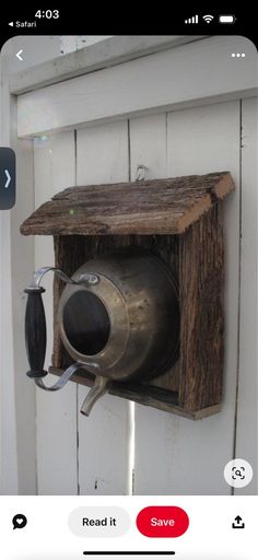 an old metal cup is attached to a wooden box on the side of a door