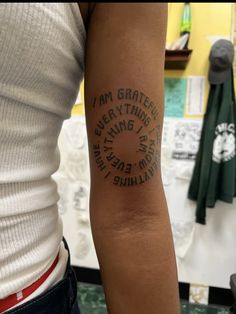 a person with a tattoo on their arm that says i am grateful everything is possible