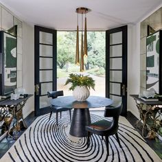 the dining room is decorated in black and white with an oval table surrounded by chairs