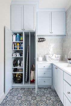 a kitchen with blue and white tile flooring, cabinets and counter tops in it