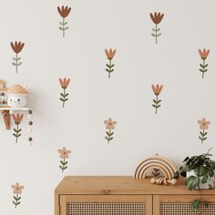 a wall with flowers painted on it and a wooden cabinet in front of the wall