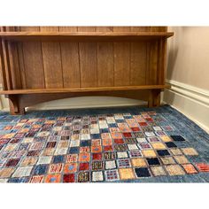 a wooden bench sitting on top of a blue rug